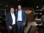 Kurt Egloff, CEO BMW Schweiz (links), und Olivier Muller, Direktor Mini, im neu gestalteten Mini-Pavillon der Auto-Graf AG in Meilen ZH; im Hintergrund das neue, zweidimensionale Mini-Logo.